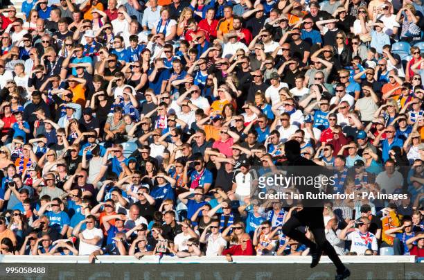 Rangers fans shade their eyes as they look into the sunshine during a pre-season friendly match at Ibrox Stadium, Glasgow.