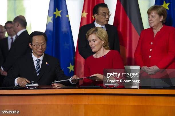 Han Changfu, China's agriculture minister, left, and Julia Kloeckner, Germanys agriculture minister, exchange a document as Li Keqiang, China's...