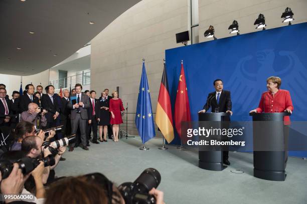Li Keqiang, China's premier, left, speaks beside Angela Merkel, Germany's chancellor, during a news conference at the Chancellery building in Berlin,...