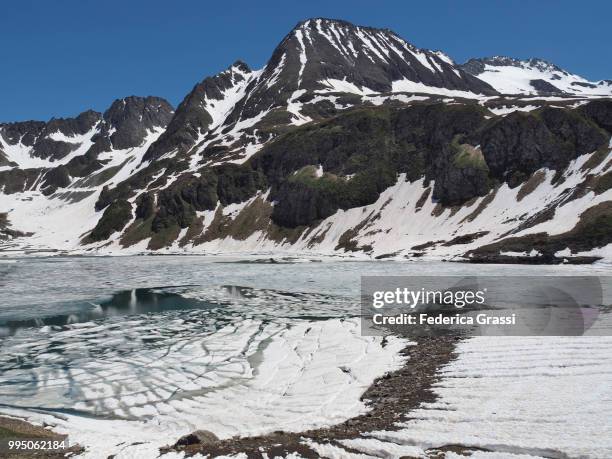 mount kastelhorn and lake kastel or castel in formazza valley - steensoorten stockfoto's en -beelden