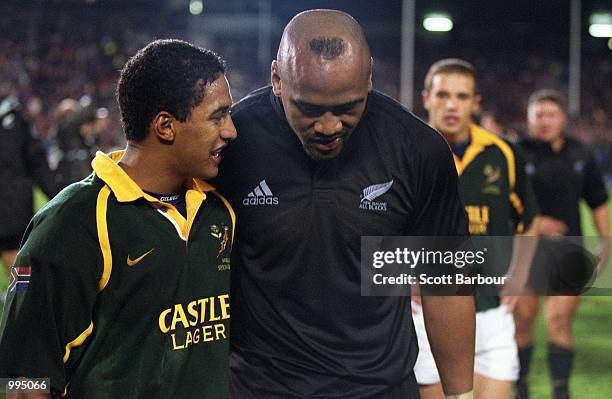 Breyton Paulse of South Africa and Jonah Lomu of New Zealand chat as they leave the field after the Tri Nations match between New Zealand and South...