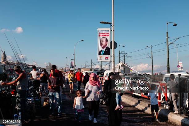 Tourists and local people walk on the Galata Bridge which is connected with two sides of Golden Horn on 8 July