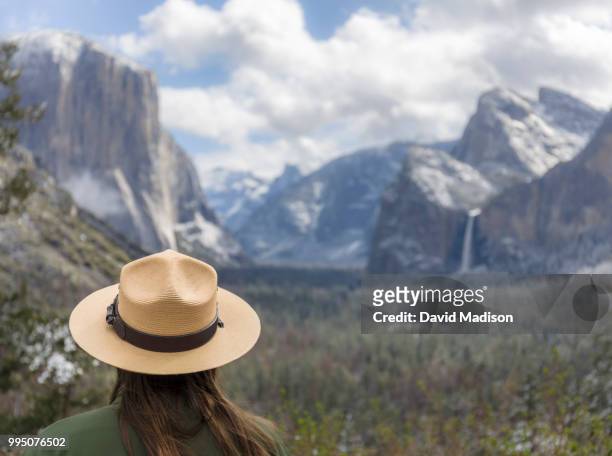 woman wearing ranger hat at tunnel view, viewing yosemite valley - el capitan yosemite national park stock pictures, royalty-free photos & images