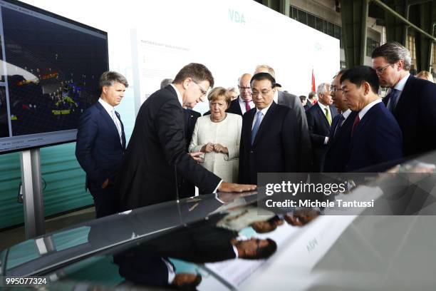 Klaus Froehlich manager at BMW and Harald Krueger BMW CEO explain the Automotive technology to German Chancellor Angela Merkel and Chinese Premier Li...