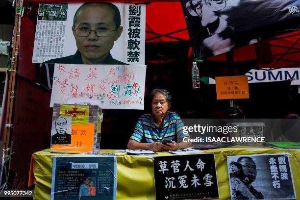 Man sits at a booth set up for late Chinese Nobel laureate Liu Xiaobo and his wife Liu Xia in Hong Kong on July 10 after reports Liu Xia who had been...