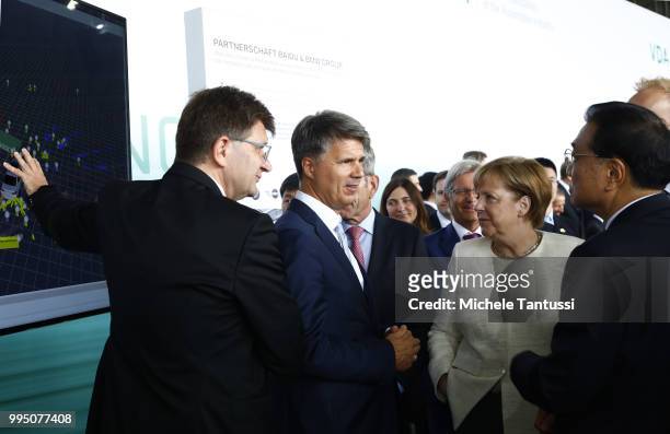 Klaus Froehlich manager at BMW and Harald Krueger BMW CEO explain the Automotive technology to German Chancellor Angela Merkel and Chinese Premier Li...