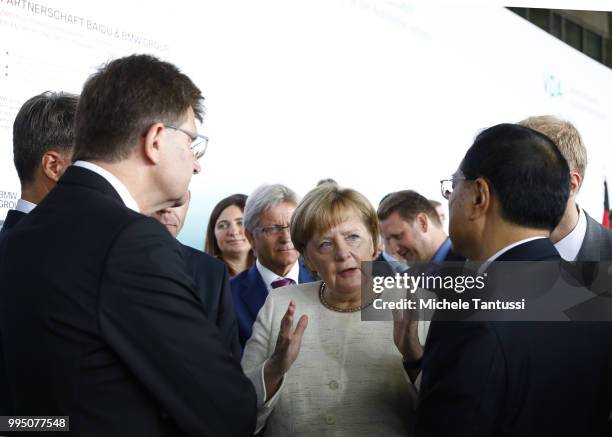 Klaus Froehlich manager at BMW and Harald Krueger BMW CEO explain the Automotive technology to German Chancellor Angela Merkel and Chinese Premier Li...