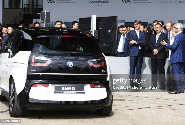 Harald Krueger BMW CEO, German Chancellor Angela Merkel and Chinese Premier Li Keqiang look at a BMW i3 as they attend an event to present a project...