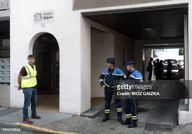 Policemen stand at the entrance of a building after five people including one child were killed when a fire tore through an apartment in Pau,...