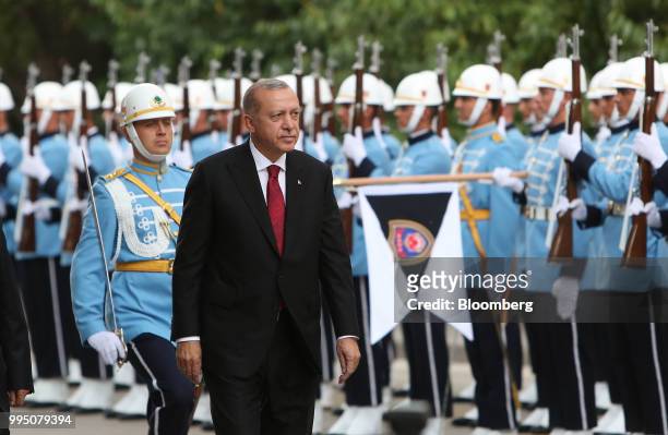 Recep Tayyip Erdogan, Turkey's president, inspects an honor guard after being sworn in under a new system of government at the Grand National...