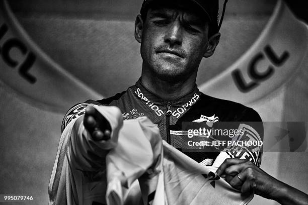 Belgium's Greg Van Avermaet puts on the overall leader's yellow jersey on the podium after the third stage of the 105th edition of the Tour de France...