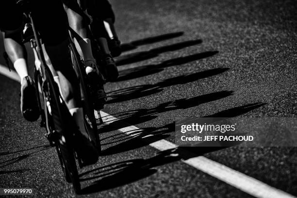 Shadows of riders of Great Britain's Team Sky cycling team are cast on the route during a training session, prior to the third stage of the 105th...