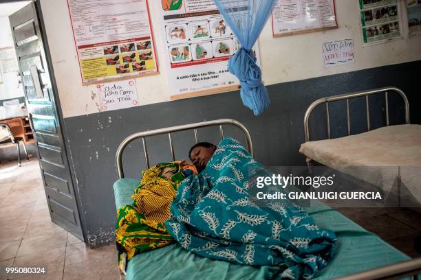 Mozambican woman lies in a hospital bed with her newborn baby inside the Murrupelane Maternity ward on July 5, 2018 in Nacala, Nampula Province,...