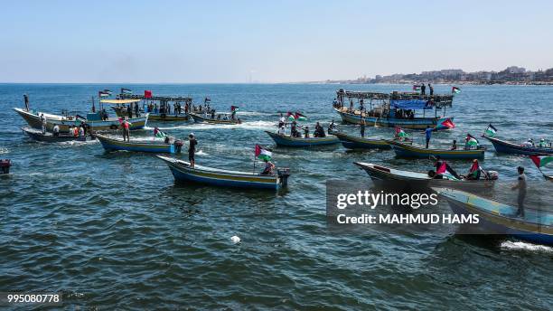 Activists escort a blockade-running boat carrying Palestinian students and others injured during protests out to sea from the Gaza City harbour on...