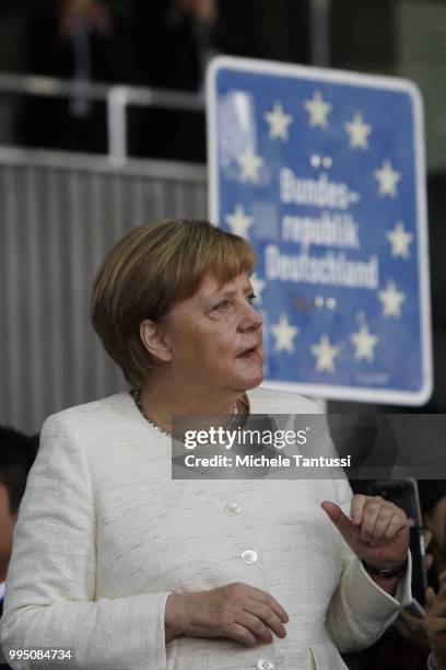 German Chancellor Angela Merkel stands in front of a old state border sign as she attends an event to present a project on autonomous driving at...