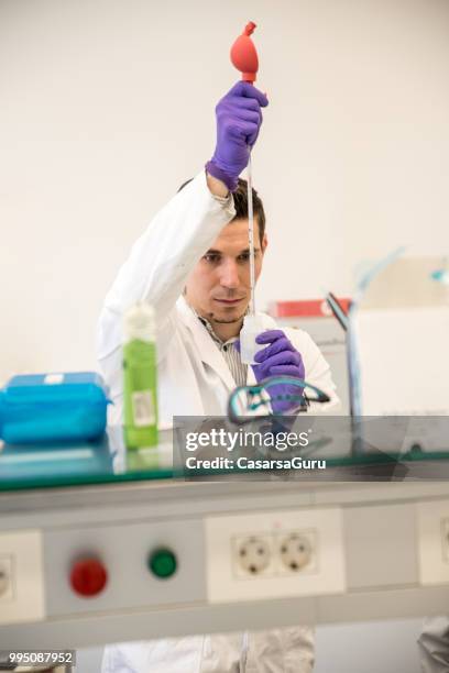 young scientist using volumetric pipette - physicist stock pictures, royalty-free photos & images