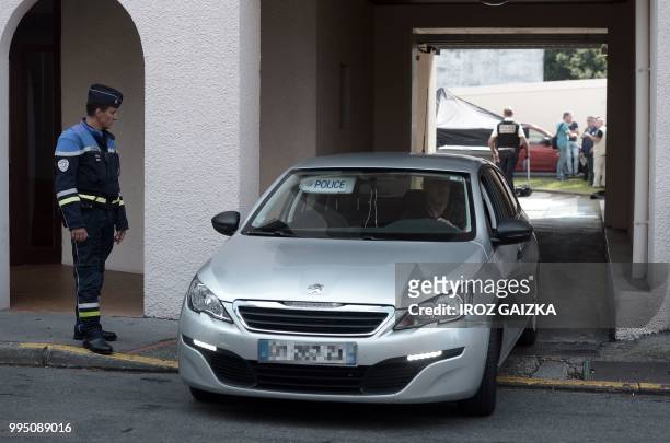 Police vehicle drives out of a building after five people including one child were killed when a fire tore through an apartment in Pau, southwestern...
