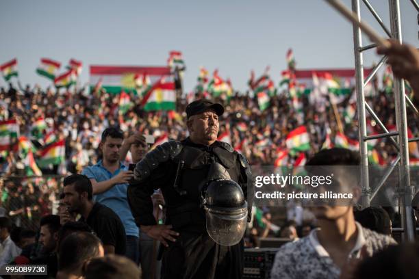 Police man listens to a speech of Kurdish President Masoud Barzani during a rally for an independent Kurdistan in Erbil, Iraq, 22 September 2017....