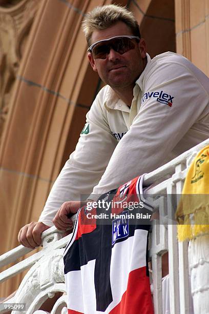 Shane Warne of Australia leans on a St.Kilder Australian rules shirt on pavilion balconey during the third day of the Second Npower Test between...