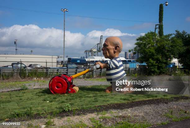 Foot sculpture of Spanish artist Pablo Picasso mowing a lawn, The Spanish Gardener by Elliott Arkin, stands on ground near the Red Hook Container...