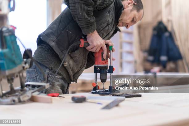 el hombre superior, carpintero, el detalle de madera en la fábrica de muebles pequeños de perforación - alex potemkin or krakozawr fotografías e imágenes de stock