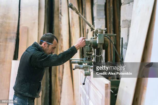 the senior 65-years-old man, sashman and carpenter, working with the industrial chain milling machine at the small wood manufacture - alex potemkin or krakozawr stock pictures, royalty-free photos & images