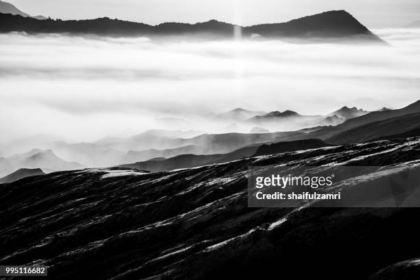 beautiful view landscape of active volcano crater with morning fog at mt. bromo, east java, indonesia. - tengger stock pictures, royalty-free photos & images