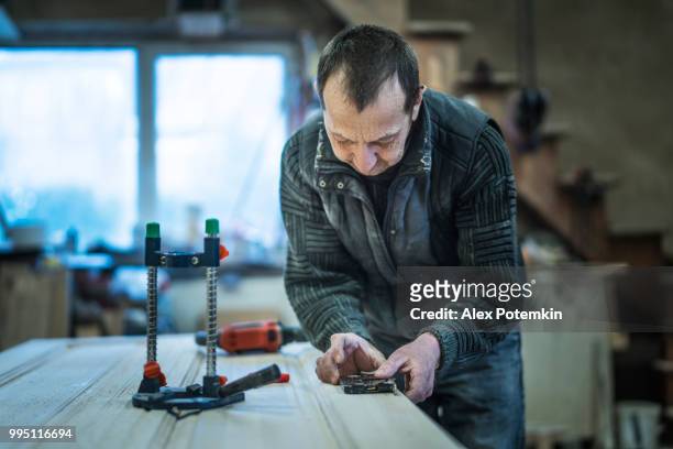 the senior man, carpenter, measuring and marking up a wooden detail for further processing. - alex potemkin or krakozawr stock pictures, royalty-free photos & images