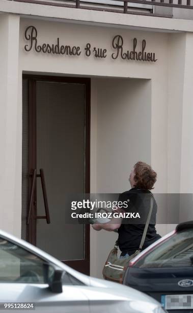 Policewoman works in front of a building after five people including one child were killed when a fire tore through an apartment in Pau, southwestern...