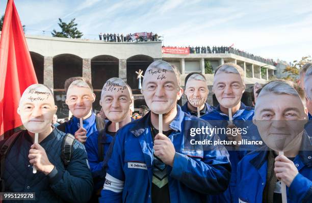 Employees of Thyssenkrupp wear masks of Heinrich Hiesinger, chairman of the management of Thyssenkrupp AG, during a protest organised by the worker's...