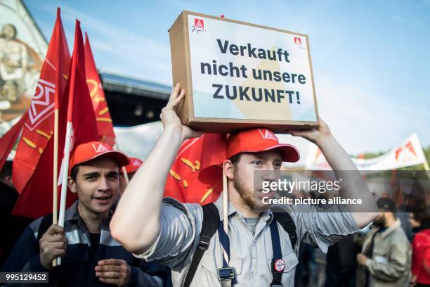 An employee of Thyssenkrupp carries a sign reading 'Verkauft nicht unsere Zukunft' during a protest organised by the worker's council and the...