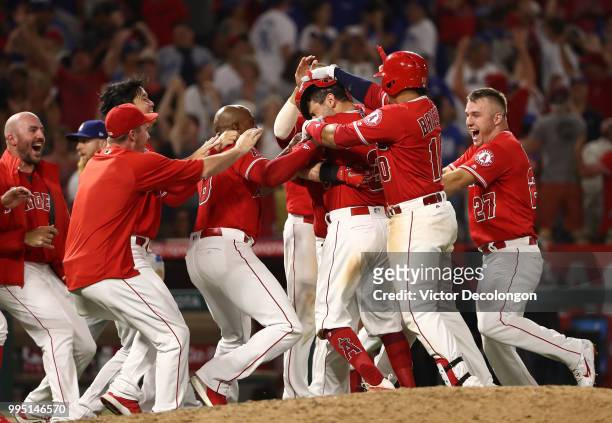 Ian Kinsler of the Los Angeles Angels of Anaheim is mobbed by teammates after hitting a single to right field which resulted in the winning run...