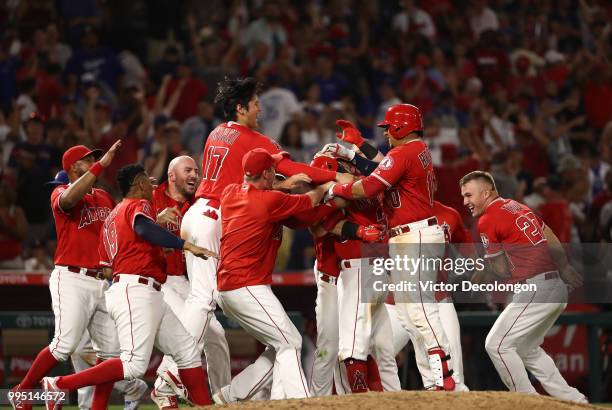 Ian Kinsler of the Los Angeles Angels of Anaheim is mobbed by teammates after hitting a single to right field which resulted in the winning run...