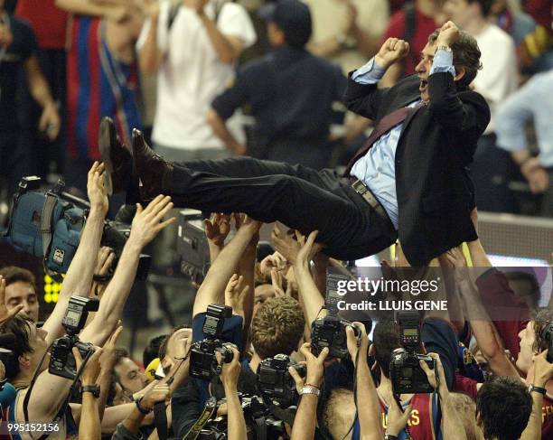 Barcelona players throw their coach, Svetislav Pesic, in the air to celebrate beating Benetton Treviso in the Euroleague Final Four match in Palau...