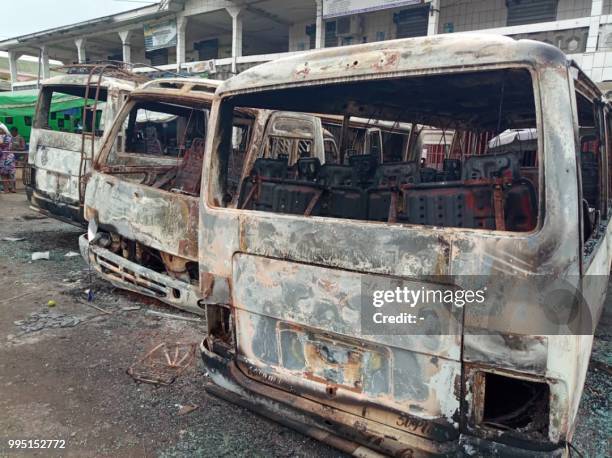 Picture taken on July 10, 2018 shows burned busses at the bus terminal in Buea. - Gunfire broke out on July 9 in Buea, the capital of a western...