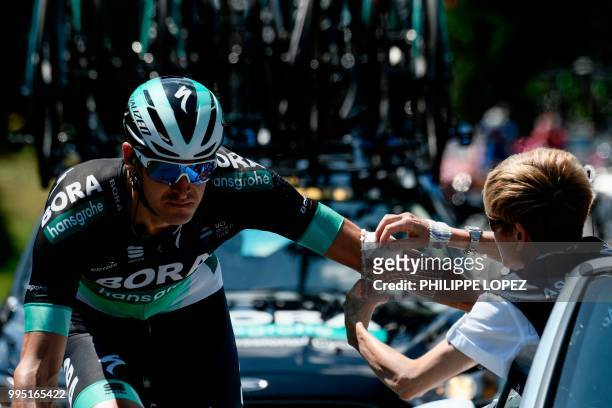 Germany's Marcus Burghardt is treated by a race medic for an elbow scratch during the fourth stage of the 105th edition of the Tour de France cycling...