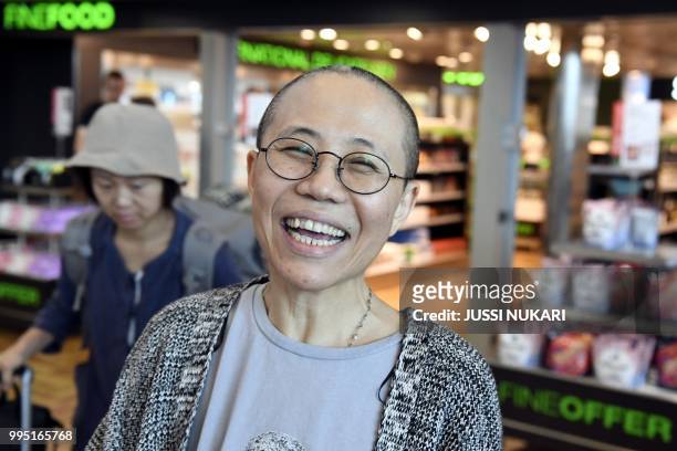Liu Xia, the widow of Chinese Nobel dissident Liu Xiaobo, smiles as she arrives at the Helsinki International Airport in Vantaa, Finland, on July 10,...