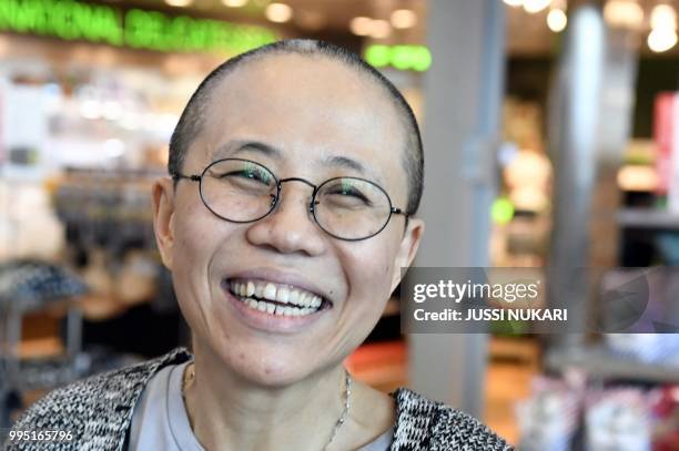 Liu Xia, the widow of Chinese Nobel dissident Liu Xiaobo, smiles as she arrives at the Helsinki International Airport in Vantaa, Finland, on July 10,...