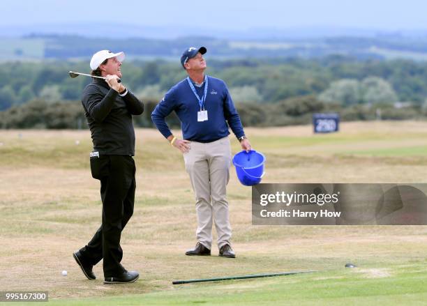 Phil Mickelson of the United States and coach Andrew Gettison watch a chip during practice for the Aberdeen Standard Investments Scottish Open at...