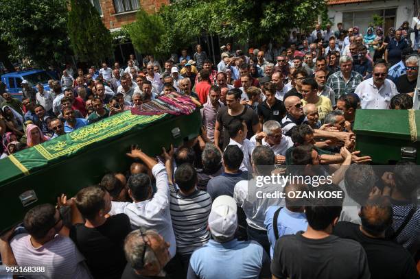 Mourners carry the coffins of Sena Kose Ozge nur Dikmen and Gulce Dikmen victims of a train accident, on July 10, 2018 during a funeral ceremony at...