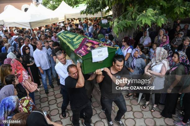 Mourners carry the coffins of Sena Kose Ozge nur Dikmen and Gulce Dikmen victims of a train accident, on July 10, 2018 during a funeral ceremony at...