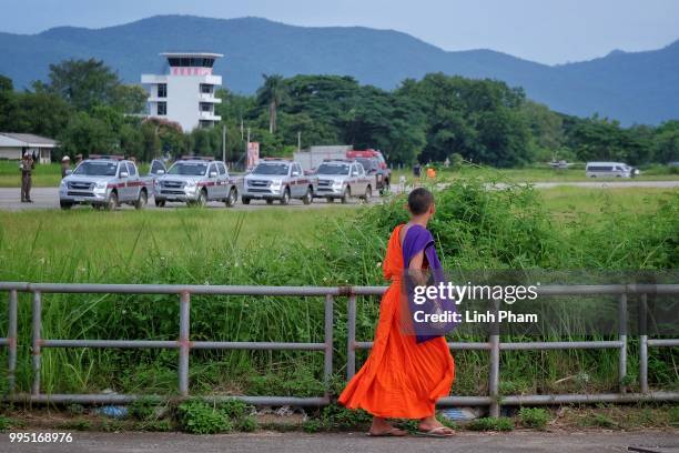 Monk passes by the helipad near Chiangrai Prachanukroh Hospital on July 10, 2018 in Chiang Rai, Thailand. Divers began an effort to free the 12 boys...