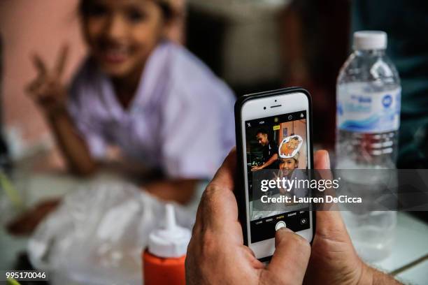 Young Thai girl wearing a wild boar hat is photographed as she waits for the boys to be delivered safely to Chiangrai Prachanukroh Hospital on July...