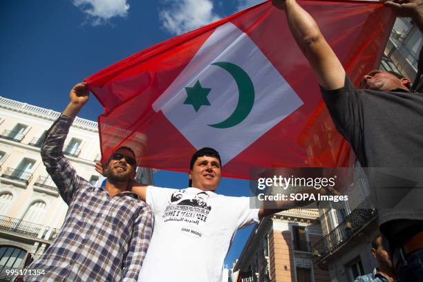 Protesters seen holding a rif flag. Members of the Hirak movement in Madrid protest demanding the release of the political prisoners of the Rif who...