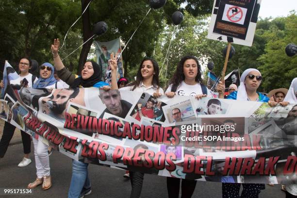 Women seen holding a huge banner. Members of the Hirak movement in Madrid protest demanding the release of the political prisoners of the Rif who...