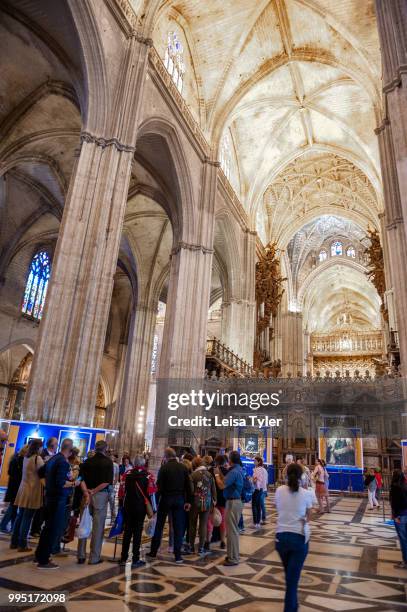 Tourists inside Seville Cathedral, Andalusia, Spain. Built on the site of the Moorish 12th century Almohad mosque, it is one of the largest Christian...