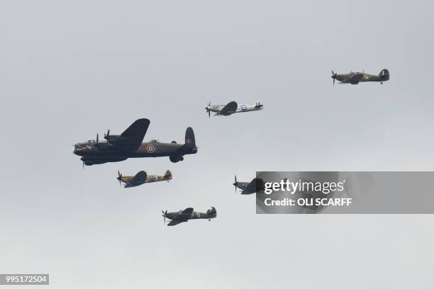 Second World War Lancaster bomber and spitfires fly in formation on the centenary of the formation of the RAF on the eighth day of the 2018 Wimbledon...