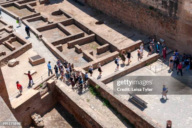 Tourists inside the original citadel, known as Alcazaba, at the Alhambra, a 13th century Moorish palace complex in Granada, Spain. Built on Roman...