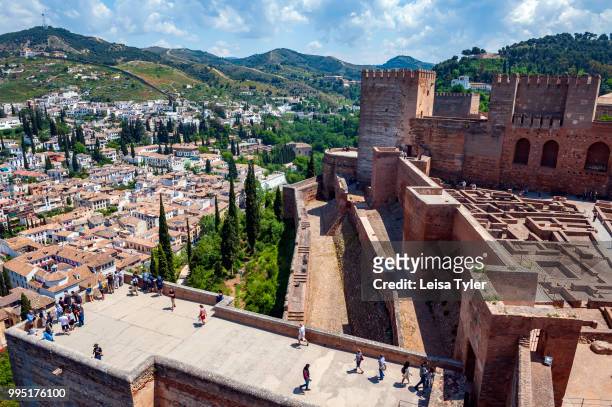 Tourists on the walls of the original citadel, known as Alcazaba, at the Alhambra, a 13th century Moorish palace complex in Granada, Spain. Built on...