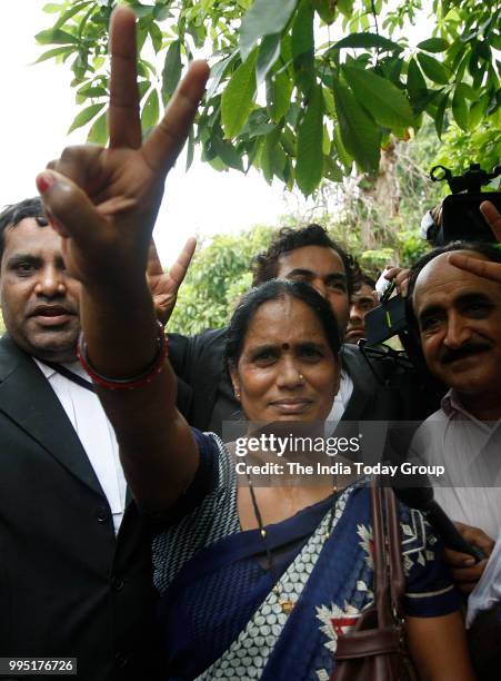 Nirbhaya's parents show victory sign after the Supreme Court's verdict in New Delhi.